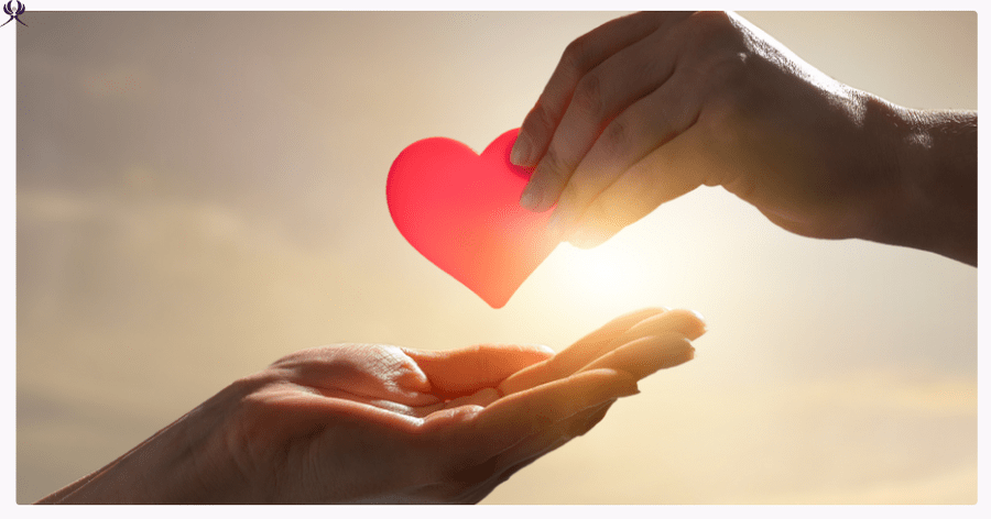 Herz wird von einer Hand in eine andere gelegt - Symbol für Liebe leben und geben